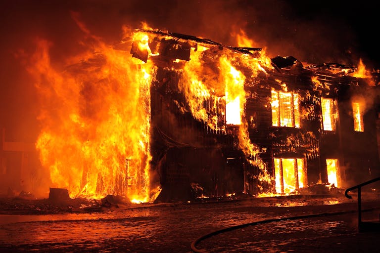 A dramatic nighttime scene of a house engulfed in flames in Tulan, Russia.